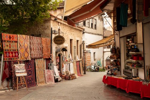 Free Explore the vibrant street market in Antalya with colorful carpets and traditional stalls. Stock Photo