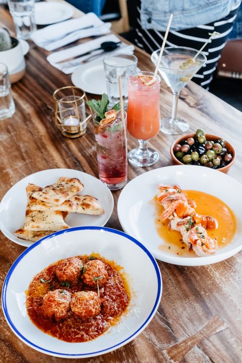 Free Rustic wooden table set with Italian dishes and colorful cocktails. A vibrant dining scene perfect for culinary exploration. Stock Photo
