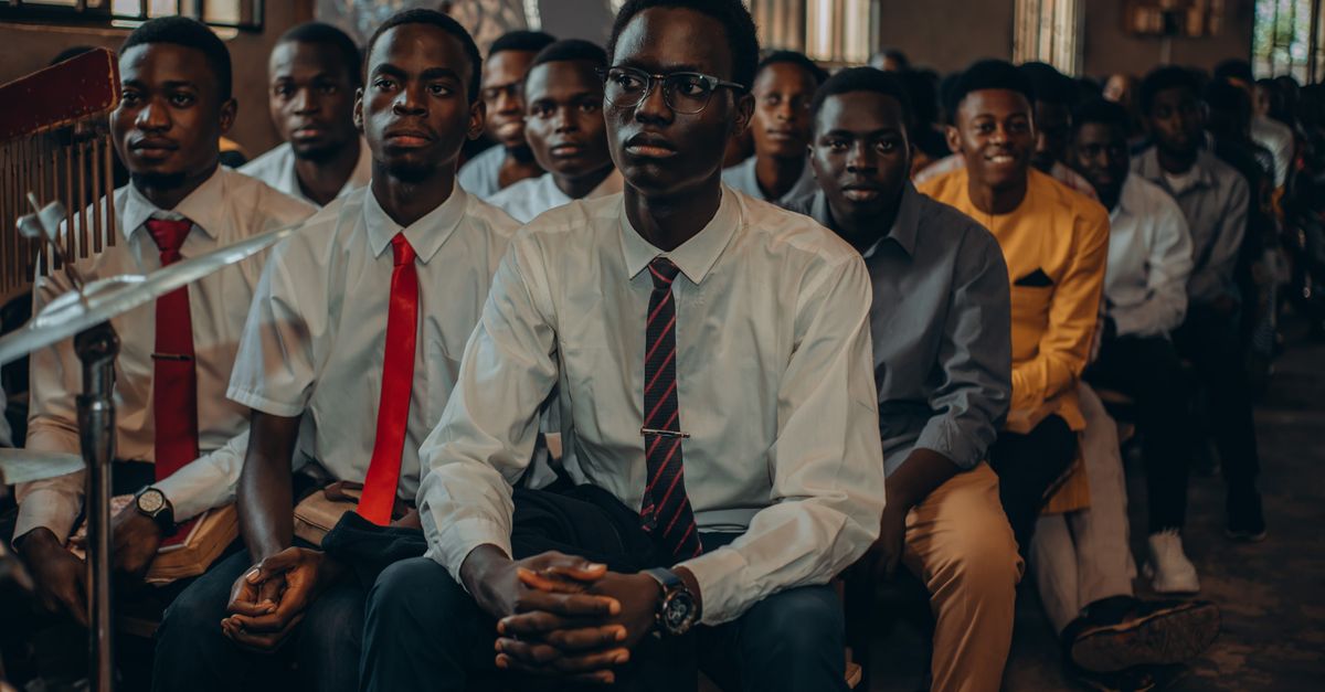 young Ghanaian students learning coding on laptops in a church community center