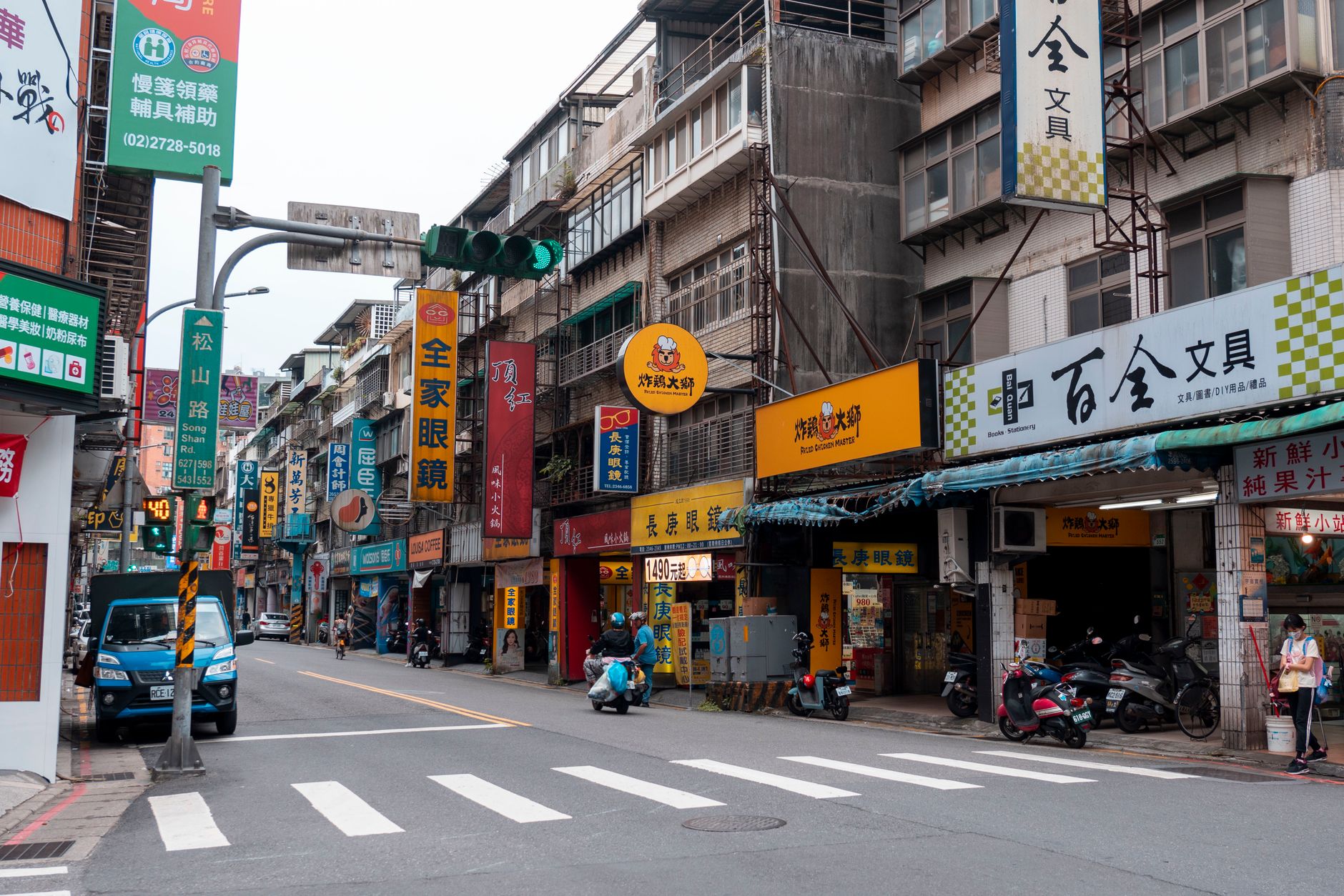 Vibrant city street featuring bustling shops and signage in Taipei, Taiwan.