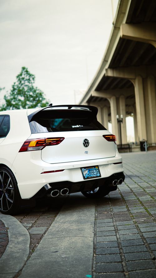 Free Modern white car parked beneath an urban highway overpass in a city setting. Stock Photo