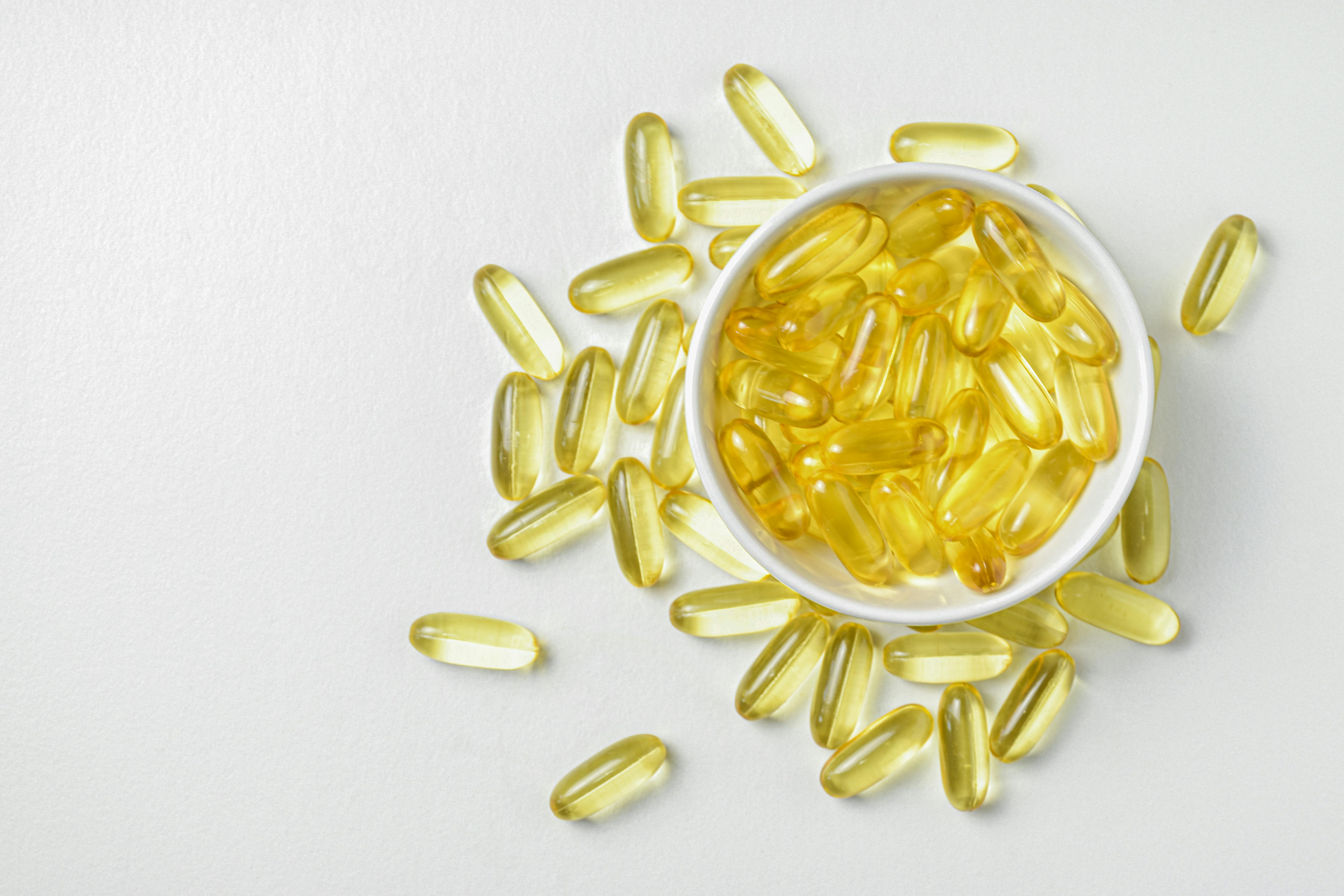 flat lay of fish oil gold capsule on background food supplement vitamin d vitamin e omega