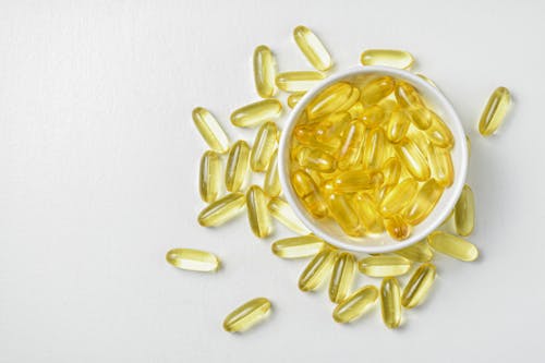 Flat lay of Fish oil gold capsule on background. Food supplement. Vitamin D. Vitamin E. Omega 3.