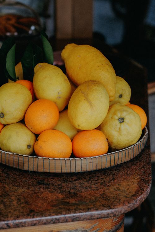 Free A fresh assortment of lemons and tangerines displayed on a rustic tray highlighting natural organic produce. Stock Photo
