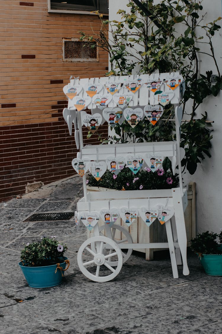 White Cart Decorated With Heart Shaped Drawings Standing Outdoors In Spring