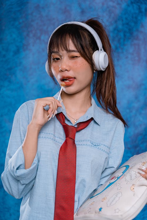 Free Girl with Lollipop in her Mouth and Headphones on her Head  Stock Photo