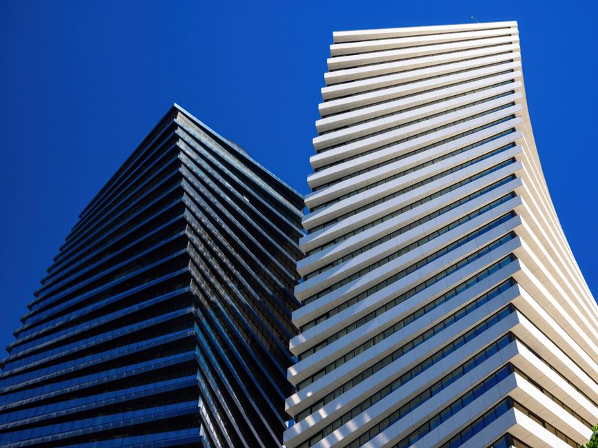 Low angle view of modern skyscrapers against a blue sky in Tbilisi, Georgia.