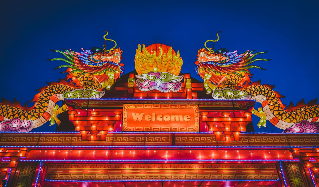 colorful illuminated dragon lanterns at a night festival with a welcom