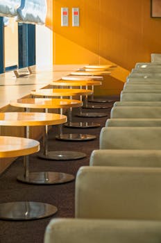 Sunlit modern waiting area in Narita, Japan with rows of seats and tables.