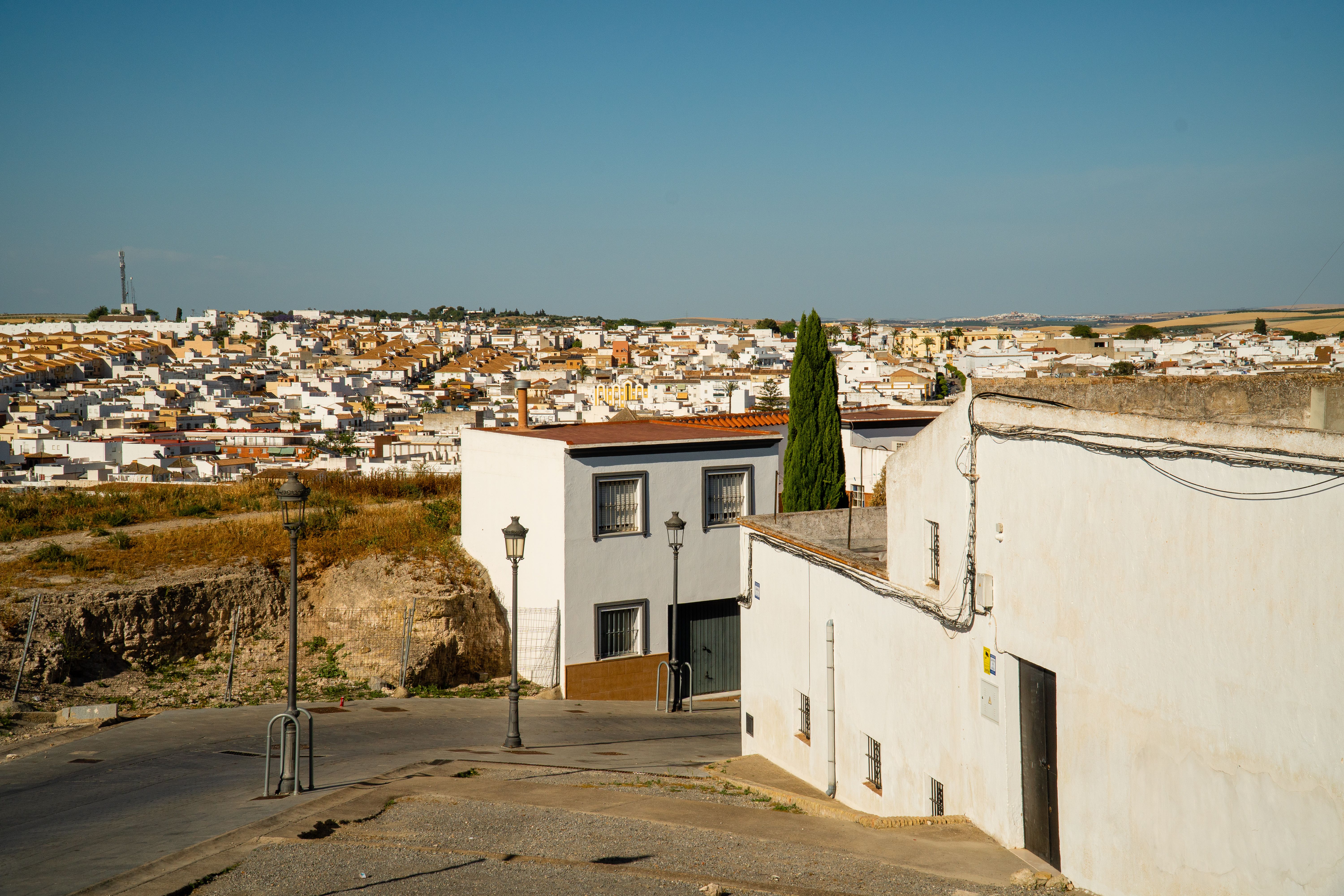 Scenic view of a southern European town with whitewashed houses under a clear blue sky.