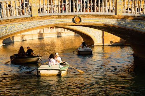 People Sailing in Boats on River under Bridges