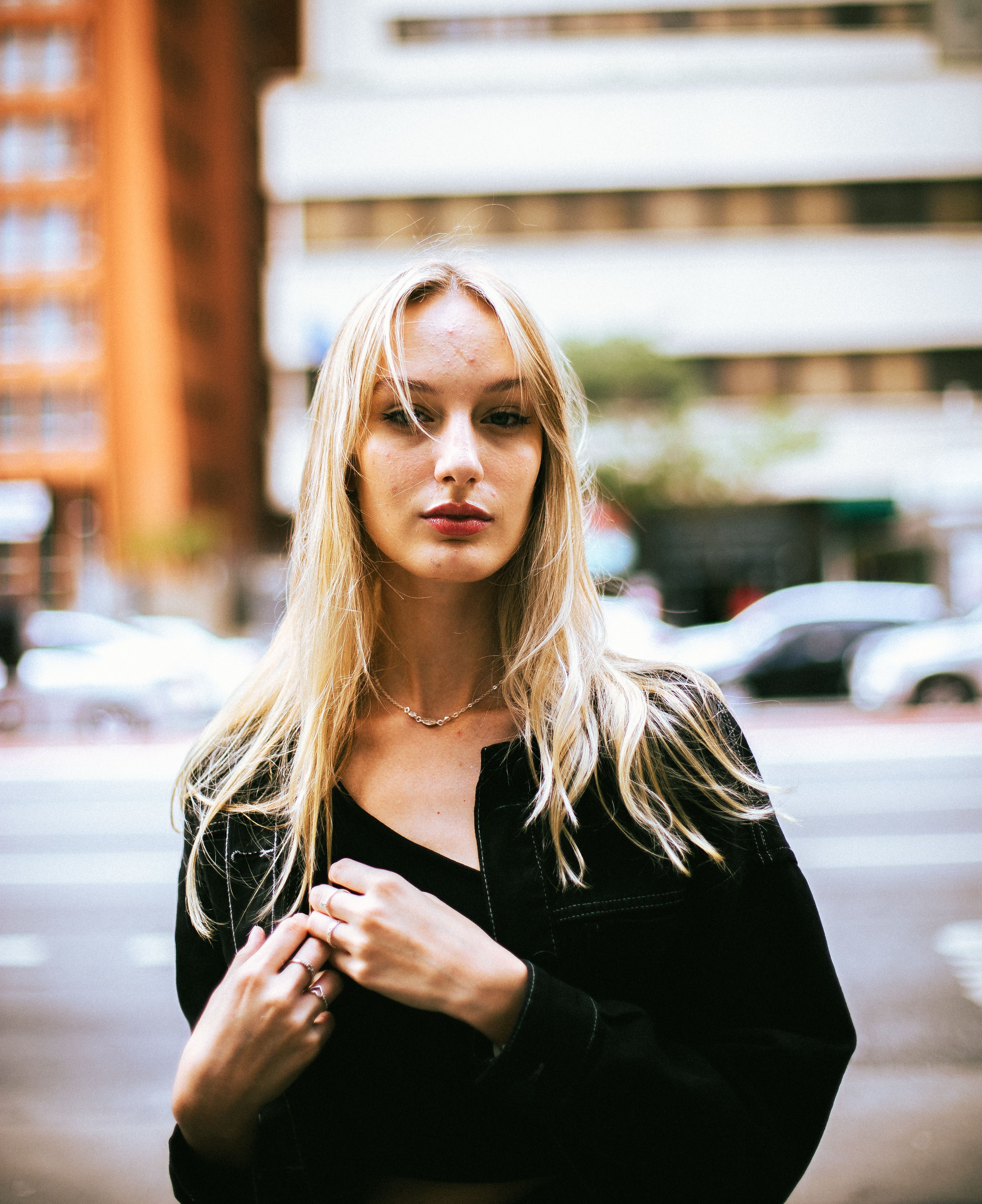 Woman in a Black Jacket Standing in the City Street · Free Stock Photo