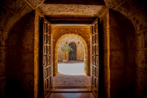 Free Captivating view through a stone archway revealing an Ottoman-style door in Mardin, Türkiye. Stock Photo