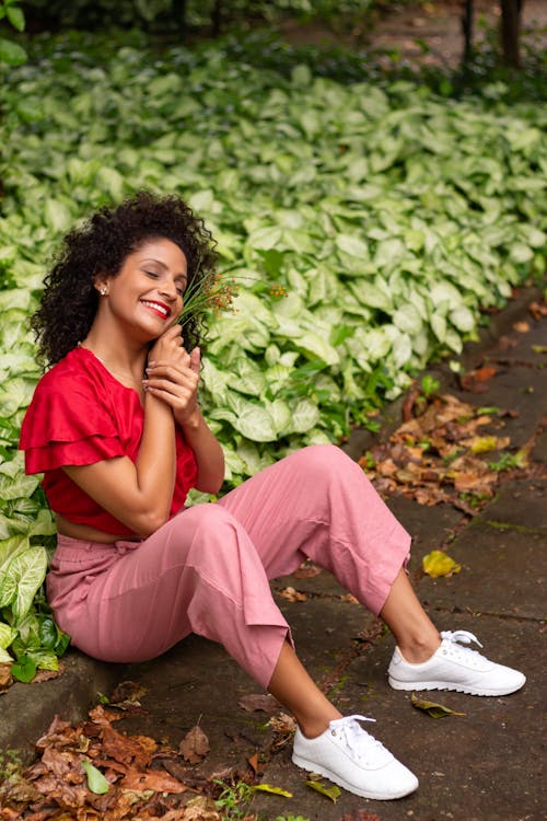 Woman Sitting on Ground and Smiling