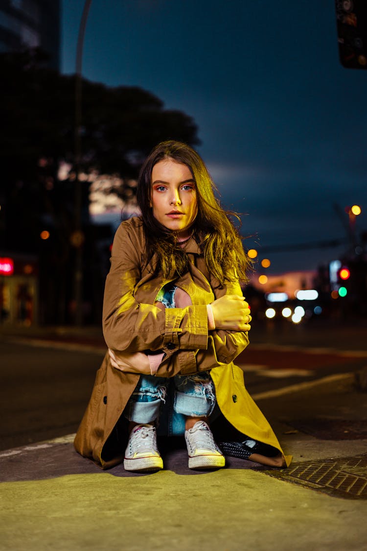 Young Woman In Coat Posing On Night Street