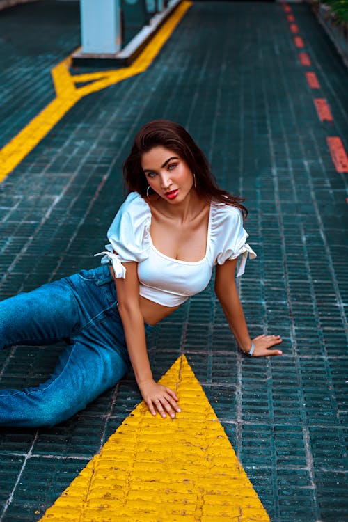 Young Woman Sitting on Ground on Parking 