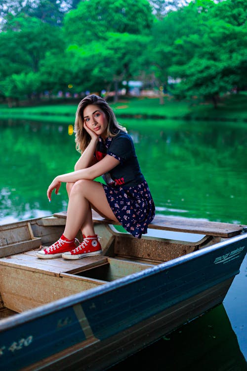 Young Beautiful Woman Sitting on Boat in Lake