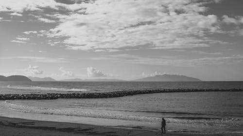 Free Black and White Photo of a Man Walking on the Beach  Stock Photo