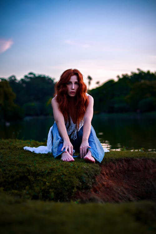 Redhead Woman Sitting on Grass