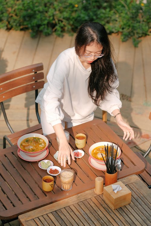 Woman Standing by Table with Food