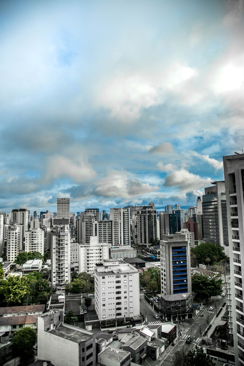 Vibrant city skyline featuring modern skyscrapers under a dynamic, cloudy sky.