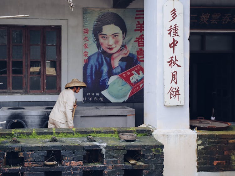 Woman Working Near Painting Of Woman On Wall