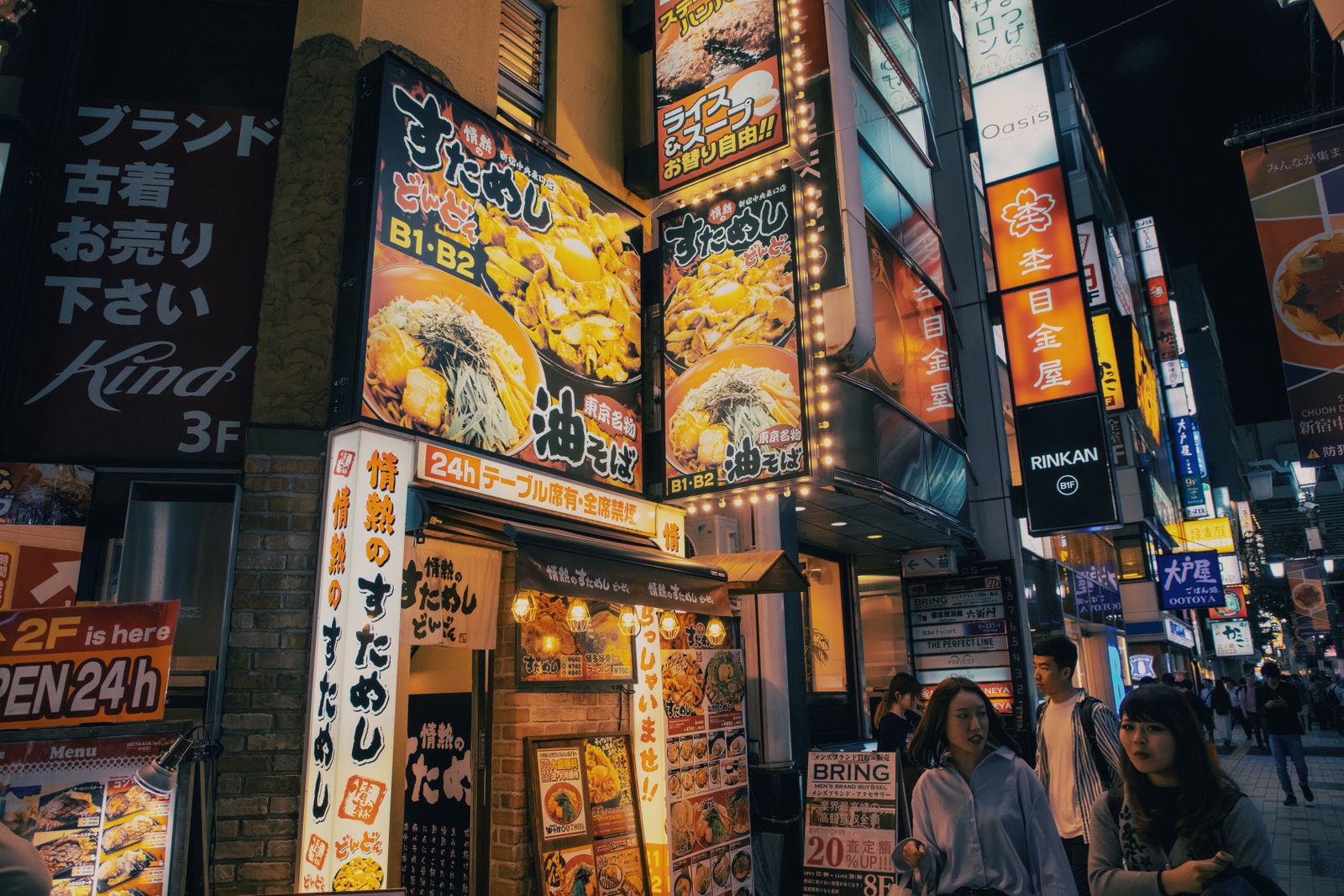 Bustling Tokyo street adorned with bright neon signs and lively atmosphere, capturing urban nightlife.