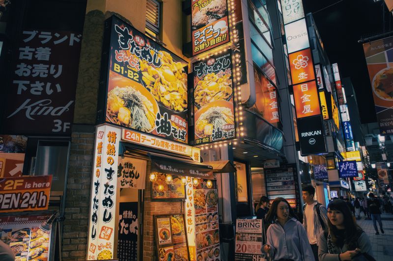 Bustling Tokyo street adorned with bright neon signs and lively atmosphere, capturing urban nightlife.