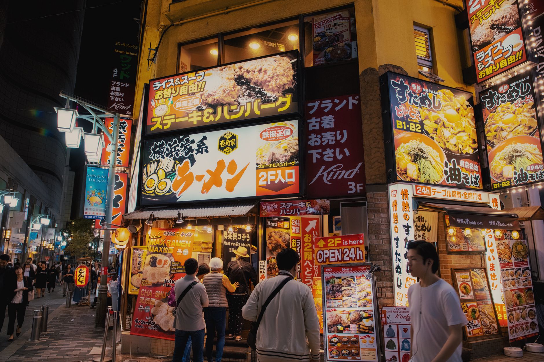 Lively Tokyo street featuring illuminated restaurant signs and bustling night activity.