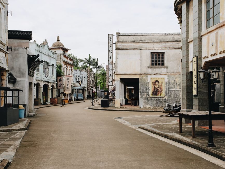 Explore a serene street in a historic old town featuring vintage facades and traditional signage.