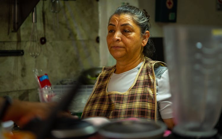 Tired Woman Sitting In A Kitchen 