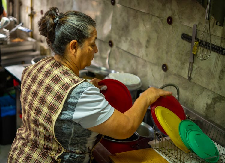 Woman Washing Dishes In A Kitchen 