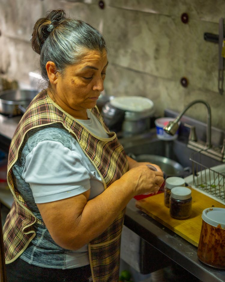 Elderly Woman Preparing Food In A Kitchen 