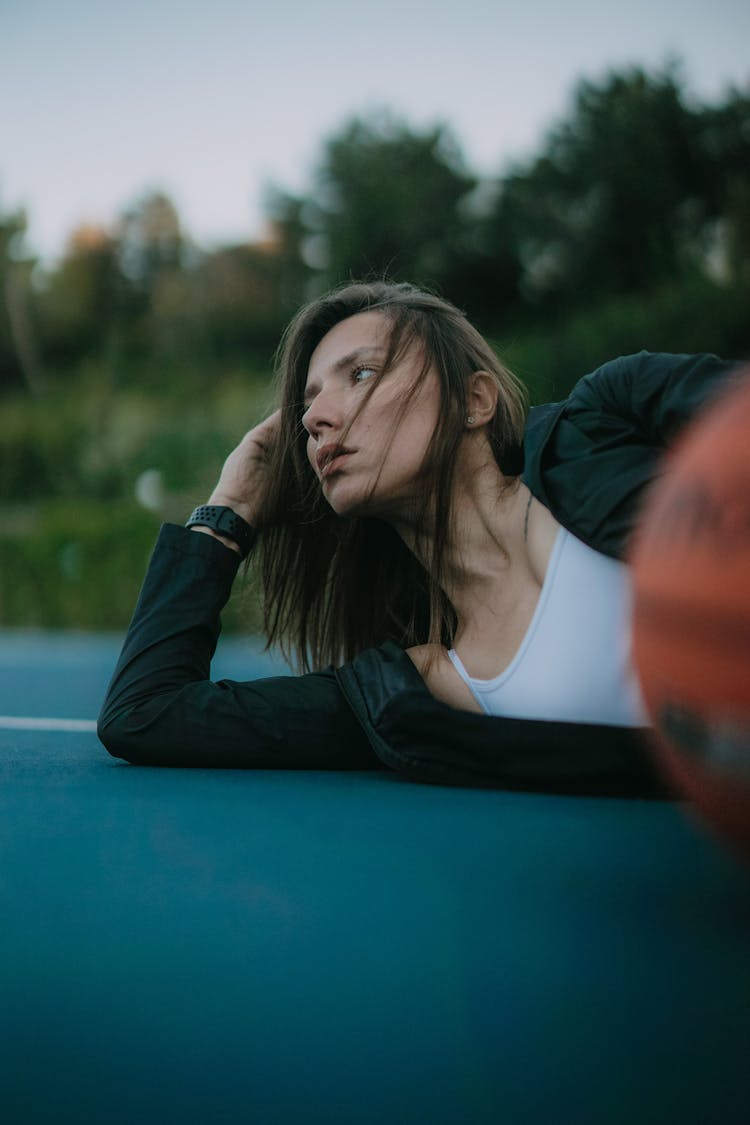 Woman Lying On A Basketball Court 