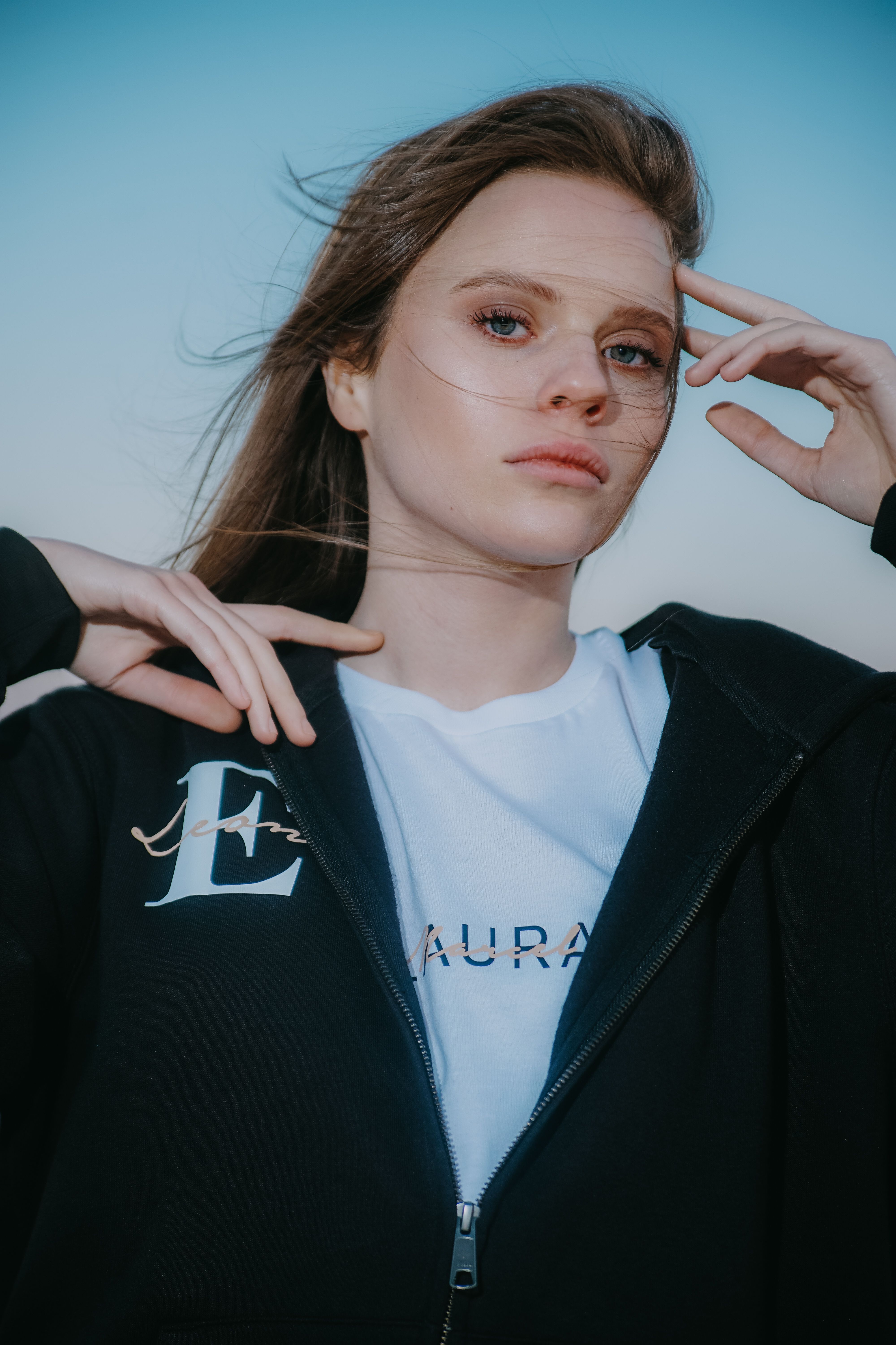 Stylish young woman posing outdoors in casual fashion wear against a clear sky in Los Angeles.