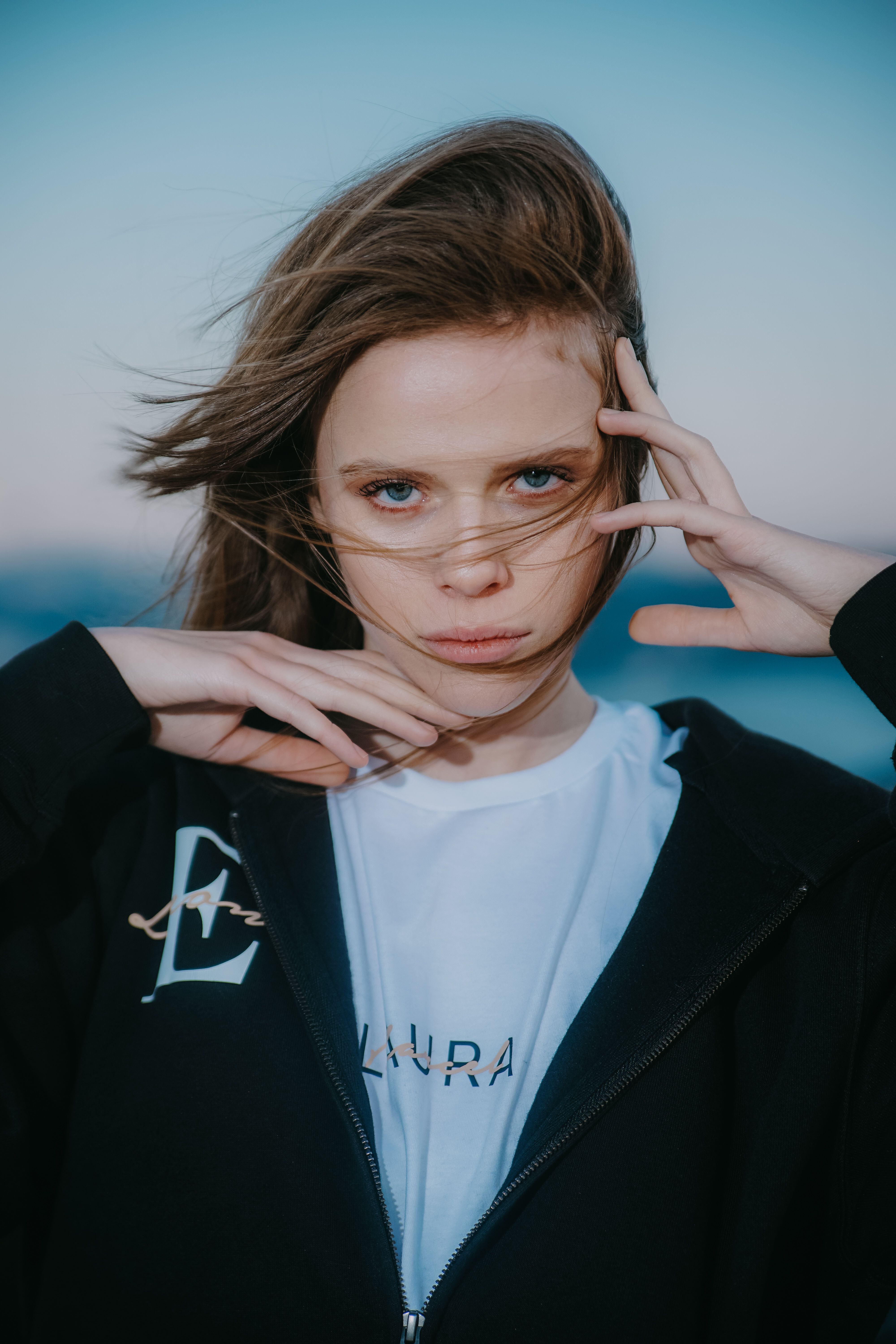 Stylish young woman posing outdoors in Los Angeles, showcasing modern fashion with a casual hoodie.