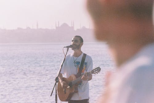 Man Playing Guitar near Water