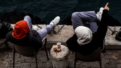 People Sitting on a Bridge by the River