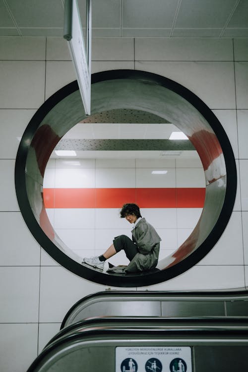 Woman Posing in a Round Opening in a Wall at a Subway Station 