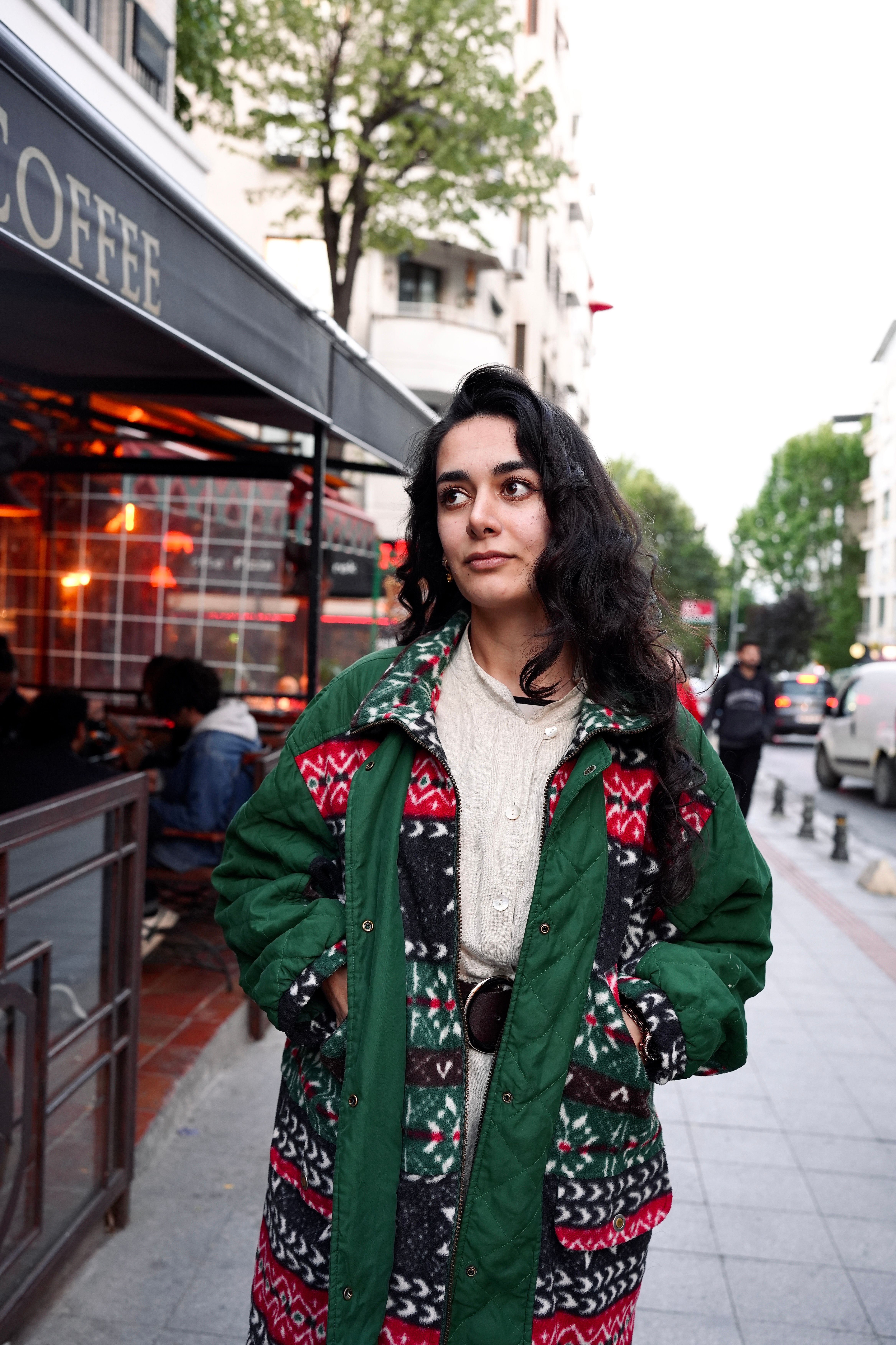 Young woman walking on a lively city street, capturing urban style and atmosphere.