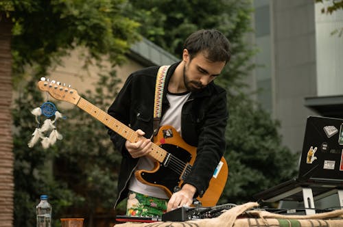 Základová fotografie zdarma na téma dívání se dolů, držení, elektrická kytara