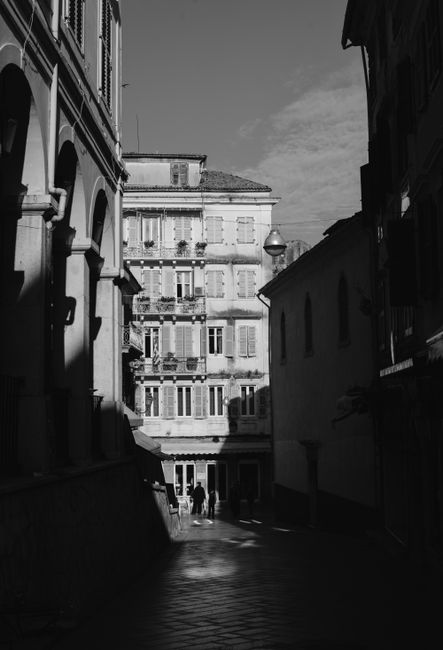Black and white photo of a historic Greek street with traditional buildings.