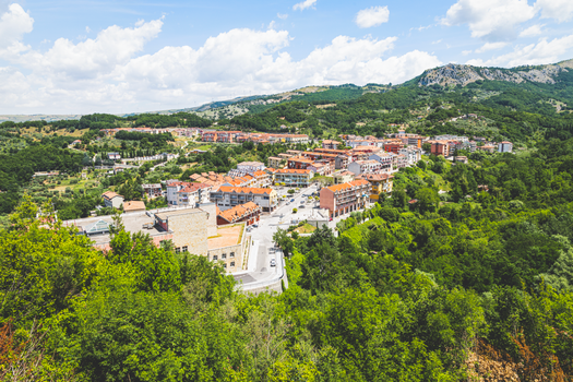 Discover the scenic landscape of Laviano, Campania, Italy from above, showcasing lush greenery and rustic townscape.