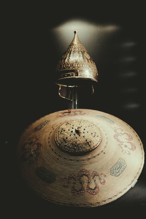 Free Artistic close-up of a medieval helmet and decorated shield with intricate designs. Stock Photo