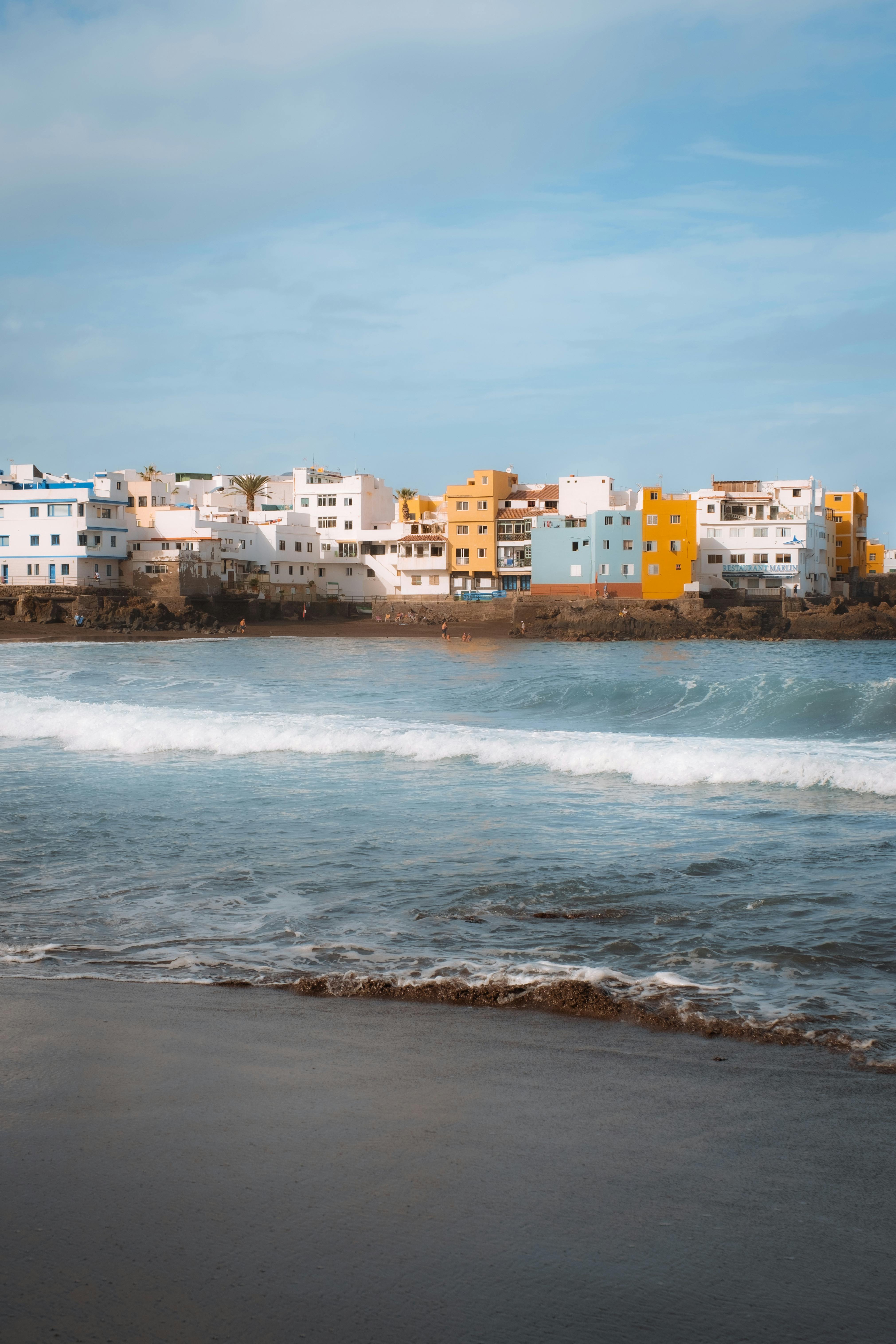 Vibrant seaside town with ocean waves, perfect for summer travel inspiration.