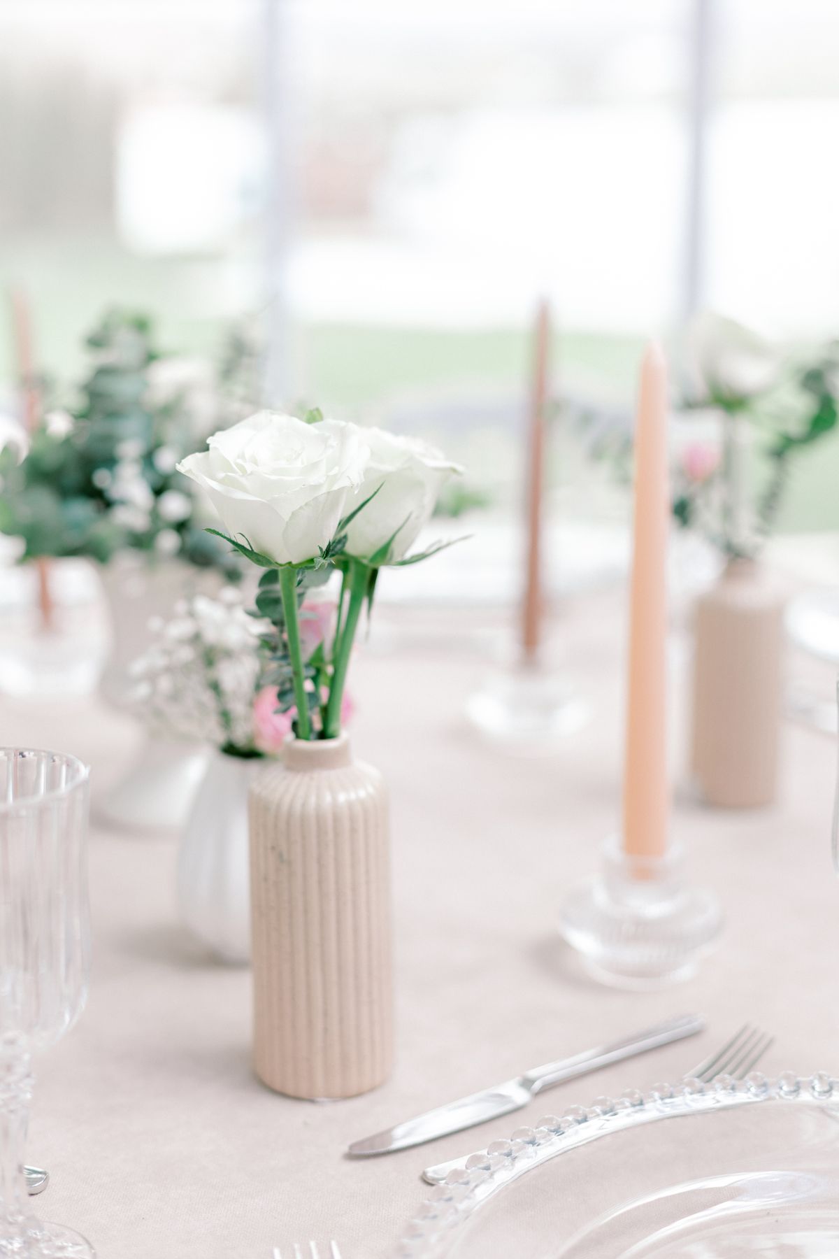 Vintage Christmas dinner table with white roses and pastel candles
