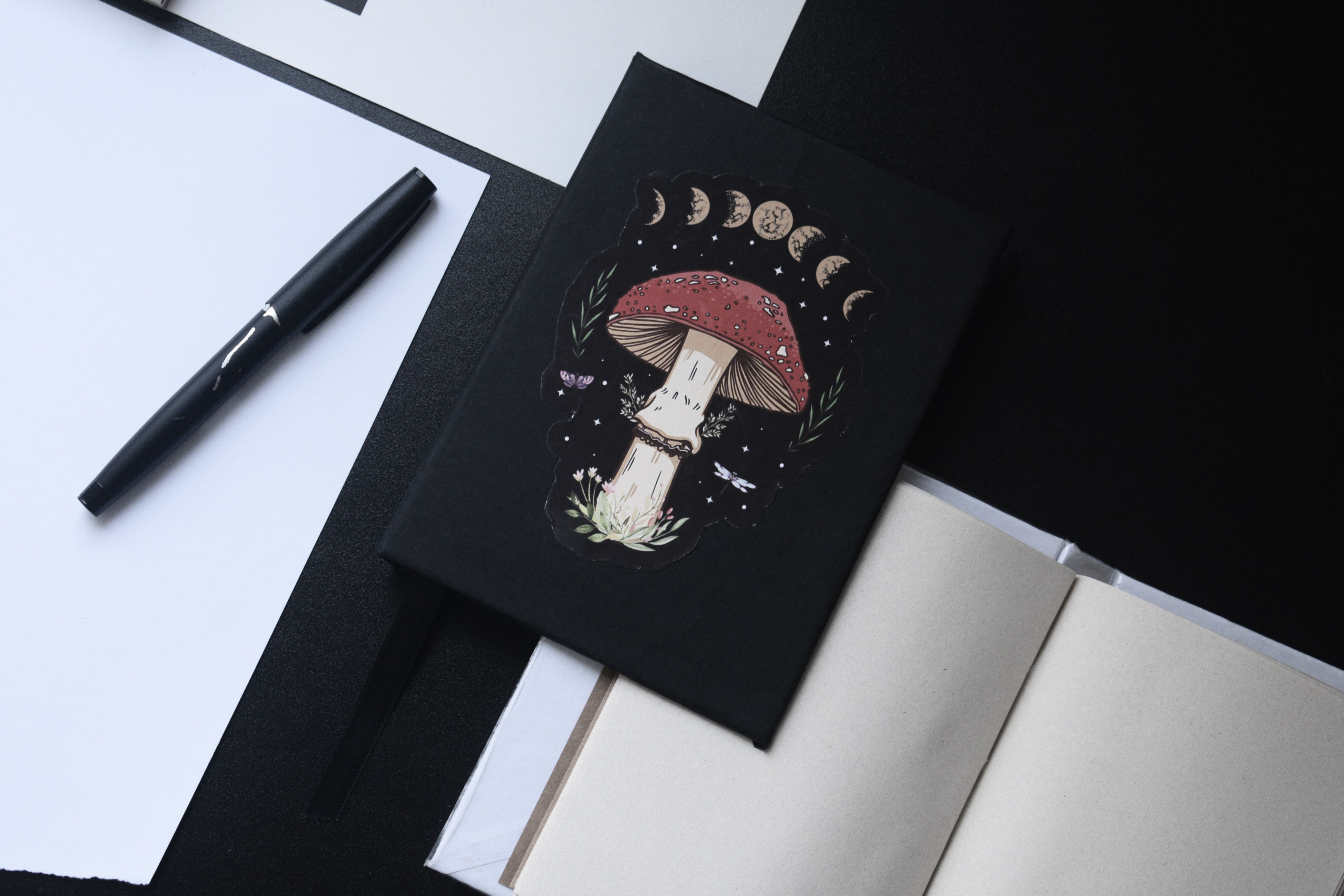 A flat lay showing moon phase jewelry, a lunar calendar app on a phone, and a journal with moon stickers