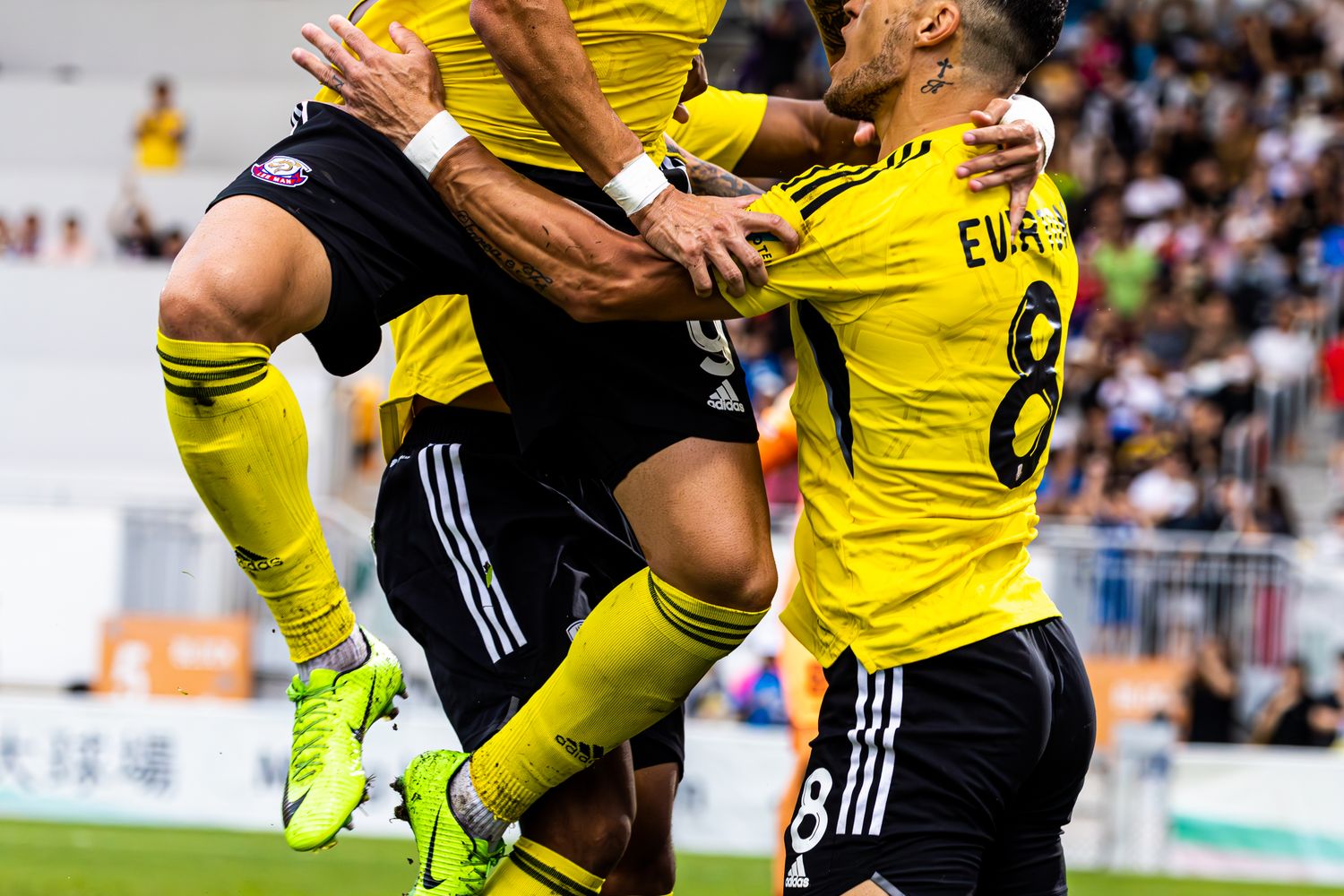 A football team celebrating together in coordinated Meridian kits