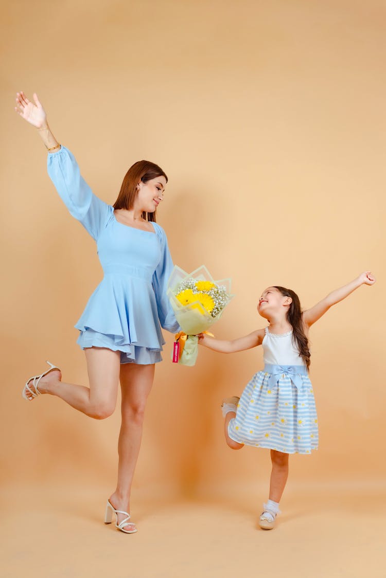 Mother And Daughter Posing Together In Studio 