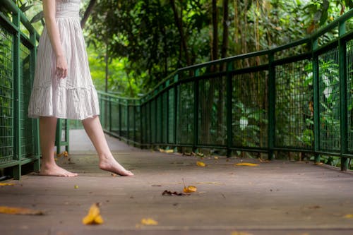 A woman in white dress standing on a bridge